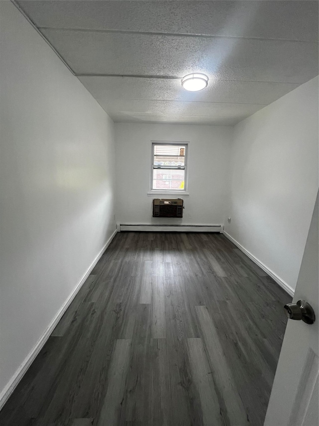 889 E 169th St, Bronx, NY 10459 - empty room with dark wood-type flooring, a baseboard radiator, and a textured ceiling