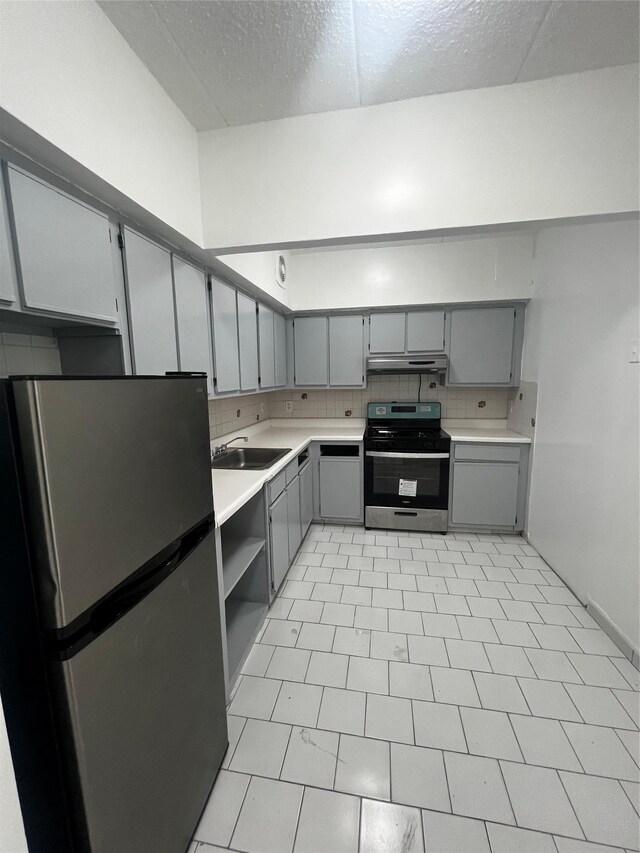 889 E 169th St, Bronx, NY 10459 - kitchen featuring appliances with stainless steel finishes, gray cabinets, under cabinet range hood, light countertops, and a textured ceiling