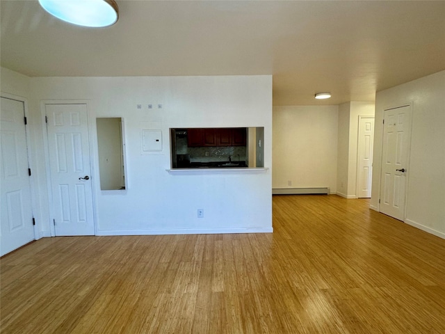 324 Concord Ln, Middletown, NY 10940 - unfurnished living room featuring a baseboard heating unit and wood finished floors