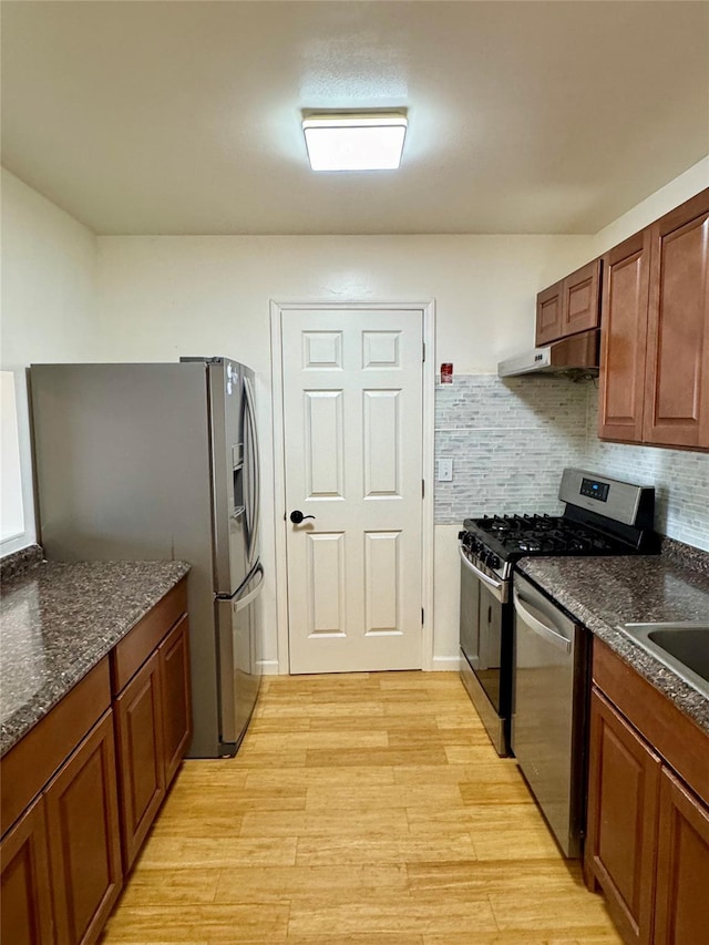 324 Concord Ln, Middletown, NY 10940 - kitchen with appliances with stainless steel finishes, under cabinet range hood, light wood-style flooring, tasteful backsplash, and brown cabinetry