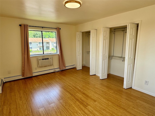 324 Concord Ln, Middletown, NY 10940 - unfurnished bedroom with two closets, light wood finished floors, and an AC wall unit