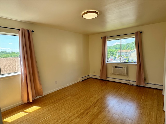 324 Concord Ln, Middletown, NY 10940 - spare room with a wall unit AC, wood finished floors, and a baseboard heating unit