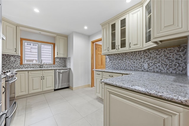 205-06 26th Ave, Bayside, NY 11360 - kitchen featuring appliances with stainless steel finishes, cream cabinets, light tile patterned floors, light stone counters, and recessed lighting