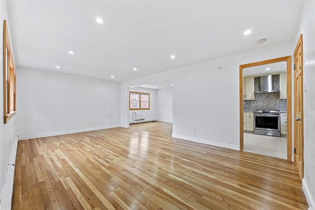 205-06 26th Ave, Bayside, NY 11360 - unfurnished living room featuring light wood-style floors, a baseboard radiator, and recessed lighting