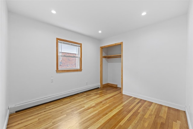 205-06 26th Ave, Bayside, NY 11360 - unfurnished bedroom featuring a baseboard radiator, light wood-style floors, recessed lighting, and a closet
