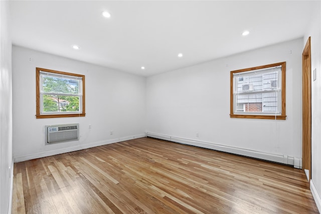 205-06 26th Ave, Bayside, NY 11360 - empty room featuring baseboard heating, a wall mounted AC, wood finished floors, and recessed lighting