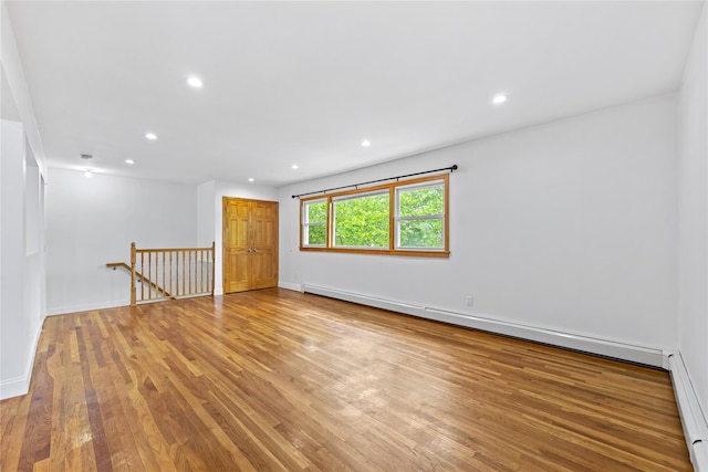 205-06 26th Ave, Bayside, NY 11360 - unfurnished room featuring a baseboard heating unit, light wood finished floors, a baseboard radiator, and recessed lighting