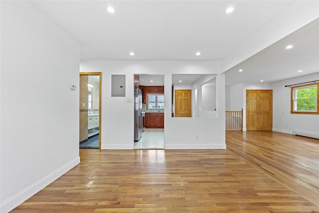 205-06 26th Ave, Bayside, NY 11360 - unfurnished living room featuring light wood-type flooring, recessed lighting, electric panel, and baseboard heating