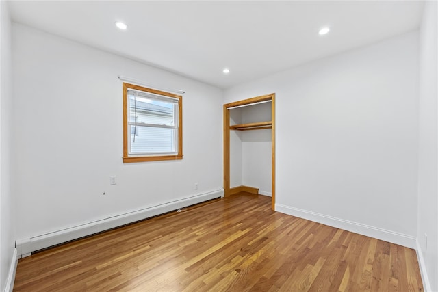 205-06 26th Ave, Bayside, NY 11360 - unfurnished bedroom with a baseboard radiator, light wood-style floors, recessed lighting, and a closet