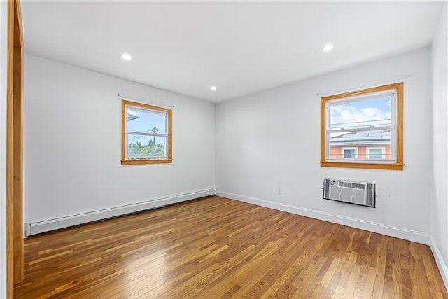205-06 26th Ave, Bayside, NY 11360 - unfurnished room with a baseboard radiator, healthy amount of natural light, an AC wall unit, wood finished floors, and recessed lighting