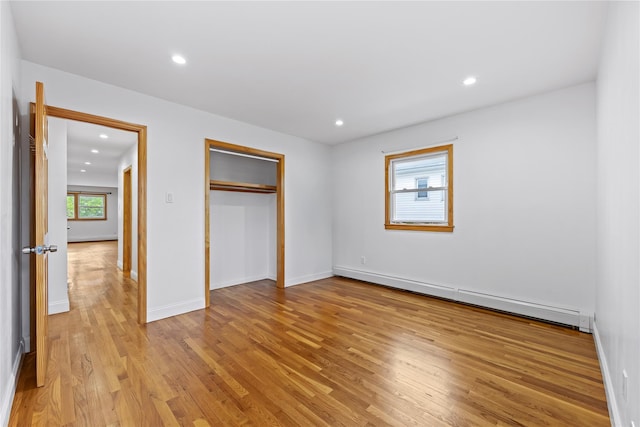 205-06 26th Ave, Bayside, NY 11360 - unfurnished bedroom featuring baseboard heating, light wood-style floors, recessed lighting, and a closet