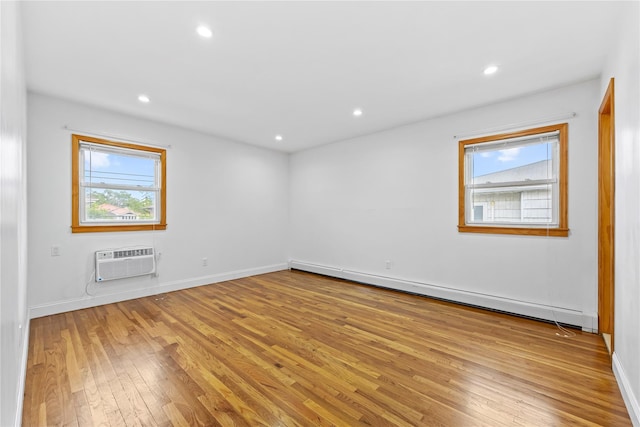 205-06 26th Ave, Bayside, NY 11360 - empty room featuring a baseboard radiator, an AC wall unit, hardwood / wood-style flooring, healthy amount of natural light, and recessed lighting