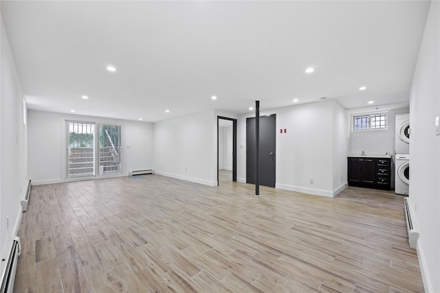 205-06 26th Ave, Bayside, NY 11360 - unfurnished living room with stacked washing machine and dryer, a baseboard heating unit, light wood-style floors, recessed lighting, and baseboard heating