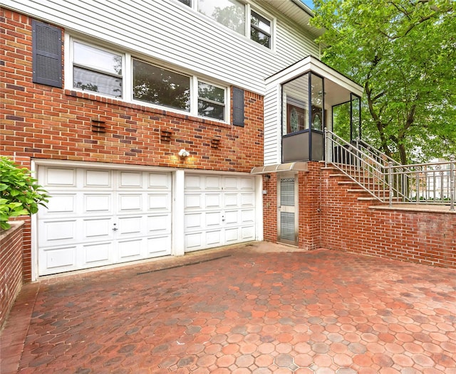 205-06 26th Ave, Bayside, NY 11360 - view of property exterior with an attached garage, brick siding, driveway, and stairway