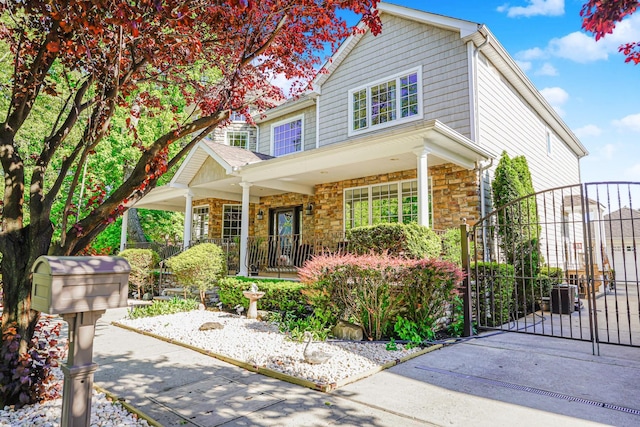 66 Normalee Rd, Staten Island, NY 10305 - traditional home featuring a gate, a porch, and stone siding