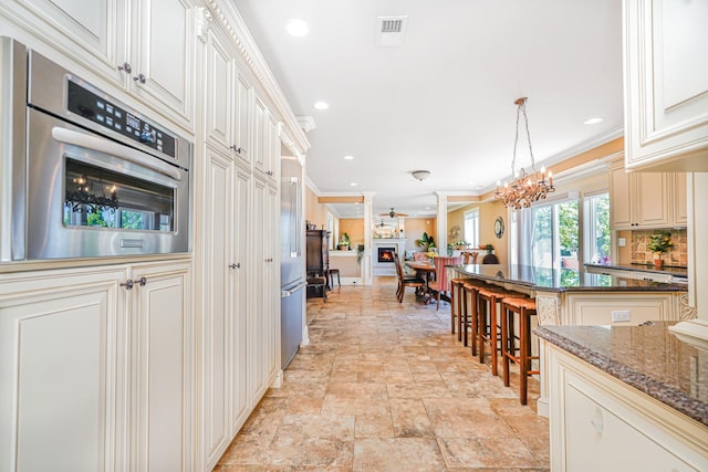 66 Normalee Rd, Staten Island, NY 10305 - kitchen featuring ornamental molding, light stone finish floors, oven, recessed lighting, and dark stone counters