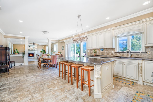 66 Normalee Rd, Staten Island, NY 10305 - kitchen featuring plenty of natural light, a breakfast bar, decorative backsplash, decorative columns, and ornamental molding