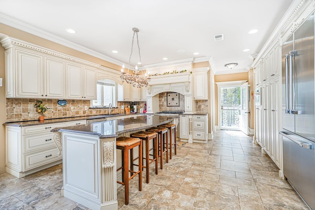 66 Normalee Rd, Staten Island, NY 10305 - kitchen with built in fridge, healthy amount of natural light, crown molding, decorative backsplash, and custom range hood