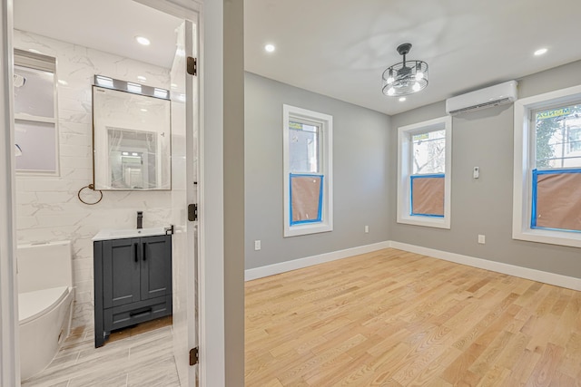 610 Sheffield Ave, Brooklyn, NY 11207 - bathroom with an AC wall unit, vanity, wood finished floors, and recessed lighting