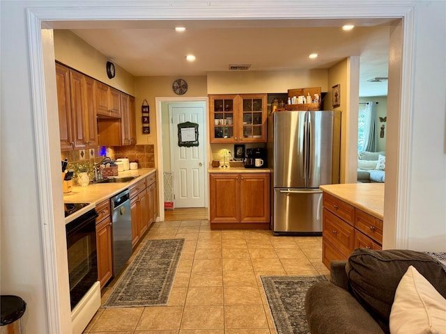 18 Division St, Cornwall, NY 12518 - kitchen featuring appliances with stainless steel finishes, light countertops, brown cabinetry, and recessed lighting