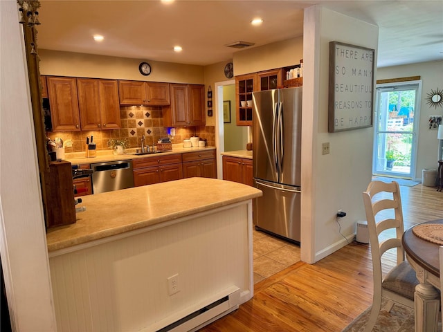 18 Division St, Cornwall, NY 12518 - kitchen featuring stainless steel appliances, light countertops, brown cabinetry, backsplash, and light wood-type flooring