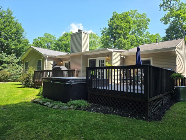 18 Division St, Cornwall, NY 12518 - back of property featuring a hot tub, a wooden deck, a lawn, and a chimney