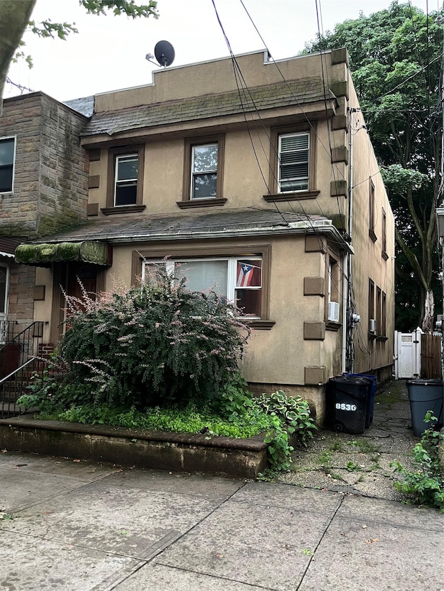 8530 101st St, Richmond Hill, NY 11418 - view of front facade with stucco siding and cooling unit