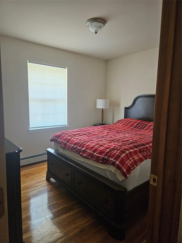 215 Sycamore Dr, New Windsor, NY 12553 - bedroom featuring a baseboard heating unit and wood finished floors