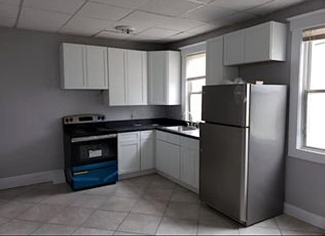 29 Fulton St, Monticello, NY 12701 - kitchen featuring freestanding refrigerator, stainless steel electric range, white cabinetry, dark countertops, and a drop ceiling
