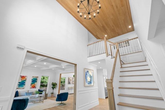 32 Middleville Rd Unit 2, Northport, NY 11768 - stairway with a decorative wall, a chandelier, wood finished floors, ornamental molding, and a wood ceiling with exposed beams