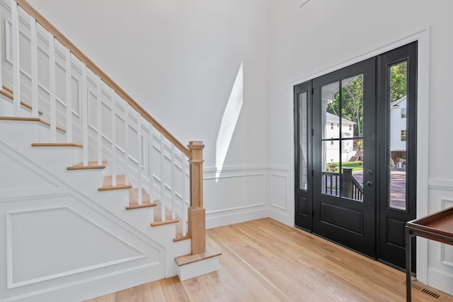 30 Middleville Rd, Northport, NY 11768 - entryway featuring wood finished floors, stairway, a decorative wall, and a wainscoted wall