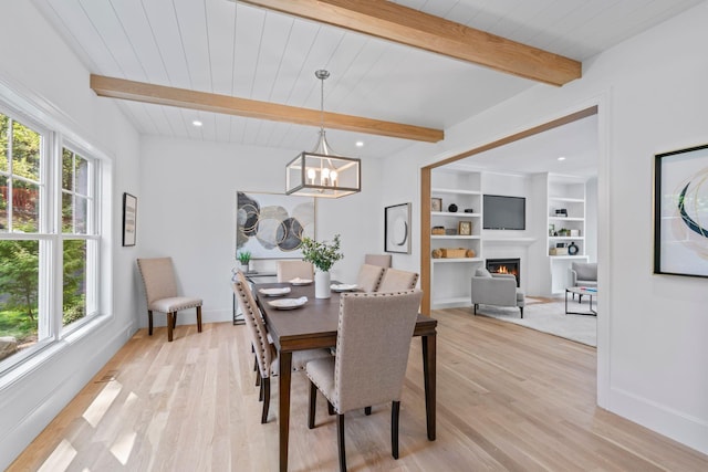 30 Middleville Rd, Northport, NY 11768 - dining room with healthy amount of natural light, light wood-type flooring, a lit fireplace, recessed lighting, and a wood ceiling with exposed beams