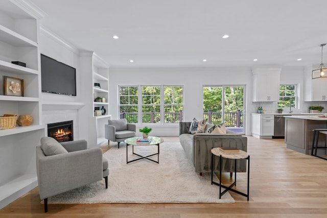 30 Middleville Rd, Northport, NY 11768 - living area featuring a glass covered fireplace, light wood-style floors, crown molding, recessed lighting, and built in features