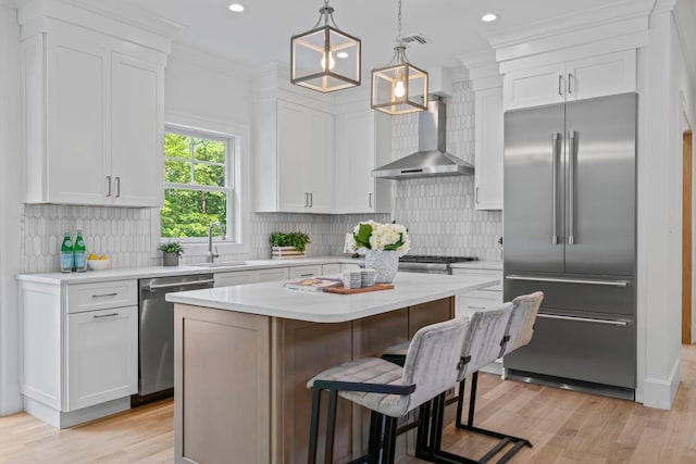 30 Middleville Rd, Northport, NY 11768 - kitchen with appliances with stainless steel finishes, wall chimney range hood, white cabinets, light countertops, and recessed lighting