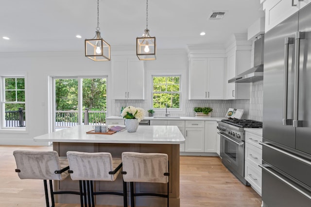 30 Middleville Rd, Northport, NY 11768 - kitchen featuring high quality appliances, light countertops, a kitchen bar, white cabinets, and ornamental molding