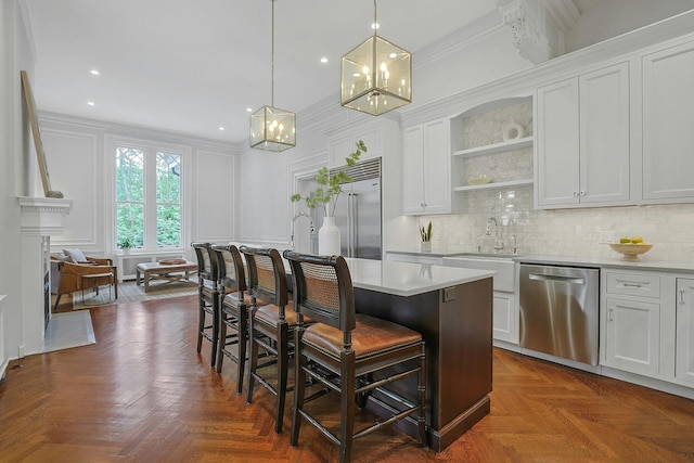 15 Calton Ln, New Rochelle, NY 10804 - kitchen with appliances with stainless steel finishes, a chandelier, a breakfast bar area, light countertops, and a decorative wall