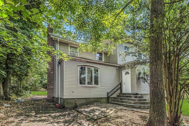 117 Glenwood Rd, Glenwood Landing, NY 11547 - rear view of house with entry steps and a chimney
