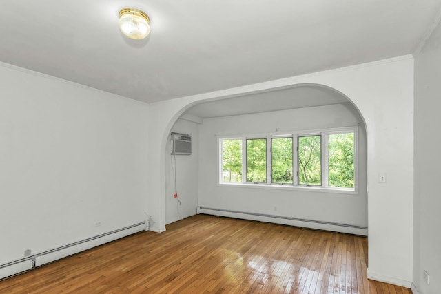 117 Glenwood Rd, Glenwood Landing, NY 11547 - empty room with a baseboard heating unit, arched walkways, hardwood / wood-style floors, an AC wall unit, and crown molding