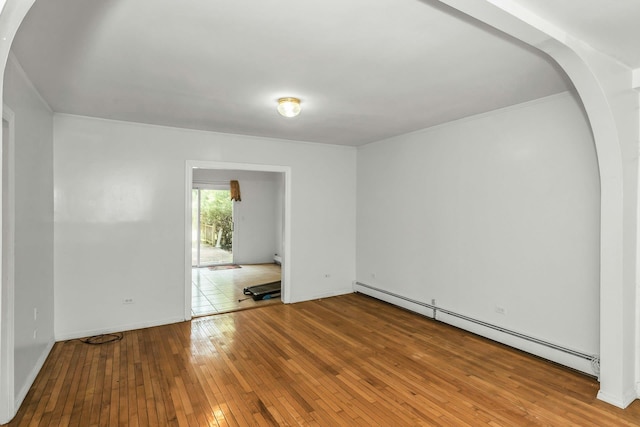 117 Glenwood Rd, Glenwood Landing, NY 11547 - empty room with a baseboard radiator, arched walkways, and hardwood / wood-style flooring