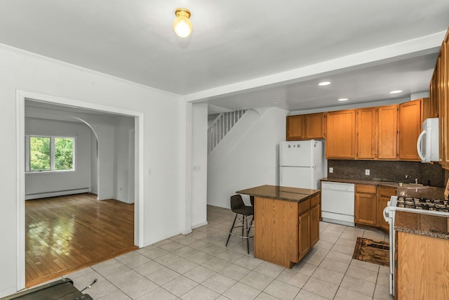 117 Glenwood Rd, Glenwood Landing, NY 11547 - kitchen featuring white appliances, a baseboard radiator, a kitchen island, backsplash, and arched walkways
