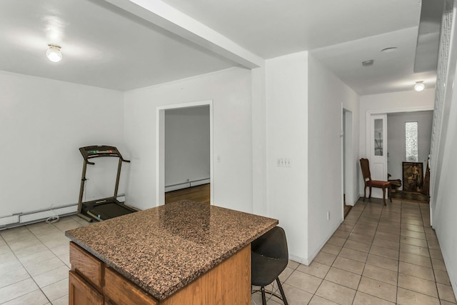 117 Glenwood Rd, Glenwood Landing, NY 11547 - kitchen with light tile patterned flooring, baseboard heating, a kitchen bar, and a center island