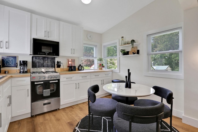 7 Brodie Rd # 17, Hopewell Junction, NY 12533 - kitchen with black microwave, stainless steel range, vaulted ceiling, light wood-style flooring, and white cabinetry