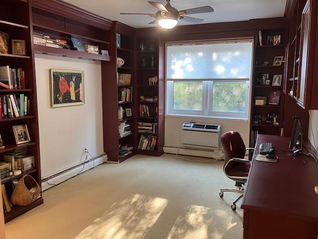 20 Chapel Pl Unit 1H, Great Neck, NY 11021 - home office featuring baseboard heating, ceiling fan, and carpet floors