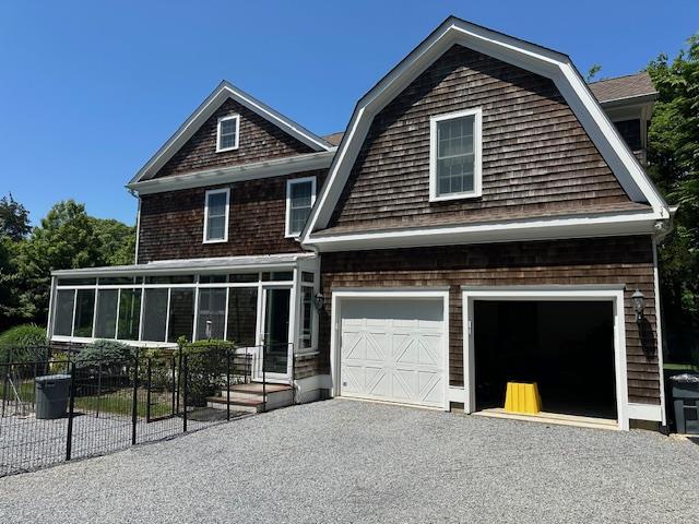 1 Sunset Ave, East Quogue, NY 11942 - shingle-style home with a sunroom, asphalt driveway, and a gambrel roof