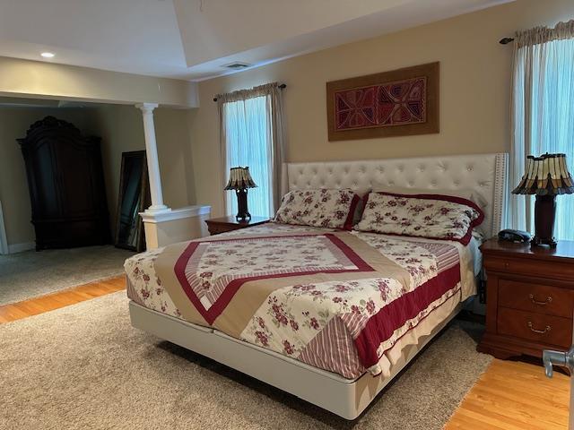 1 Sunset Ave, East Quogue, NY 11942 - bedroom with light wood finished floors and decorative columns