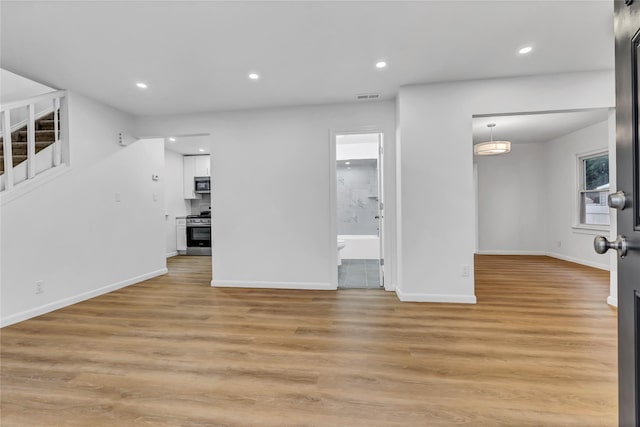 189 Jacob St, Elmont, NY 11003 - unfurnished living room with recessed lighting, light wood-style floors, and stairs