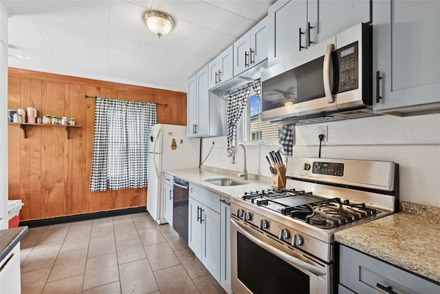35 Juniper Ave, Mineola, NY 11501 - kitchen with appliances with stainless steel finishes, light stone countertops, gray cabinets, light tile patterned floors, and wood walls