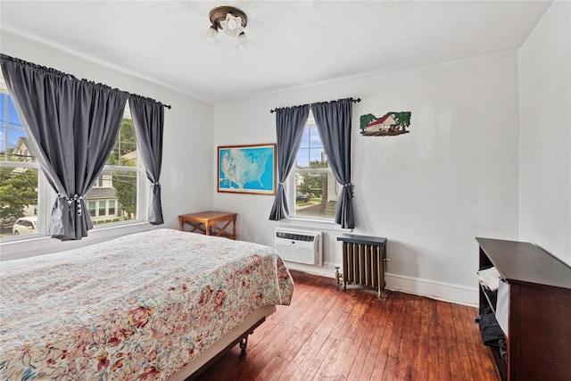 35 Juniper Ave, Mineola, NY 11501 - bedroom with radiator, multiple windows, hardwood / wood-style flooring, and a wall unit AC