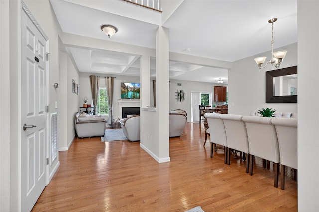 2 Primrose Ln, Chester, NY 10918 - foyer entrance featuring a chandelier, coffered ceiling, light wood-style flooring, a fireplace, and beam ceiling