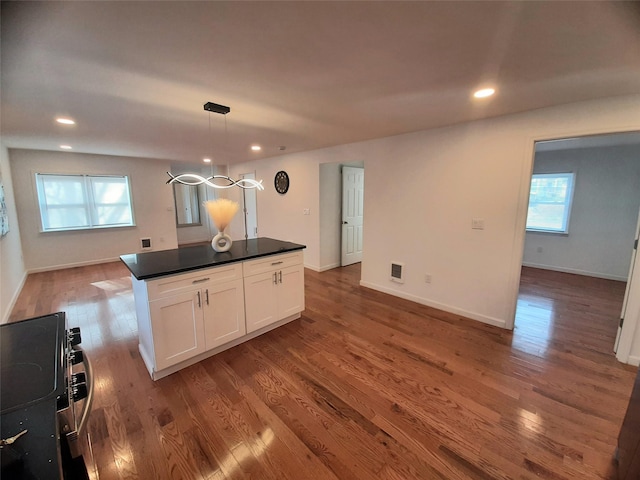 8 Poplar St, Poughkeepsie, NY 12601 - kitchen with dark countertops, white cabinetry, wood finished floors, a chandelier, and recessed lighting